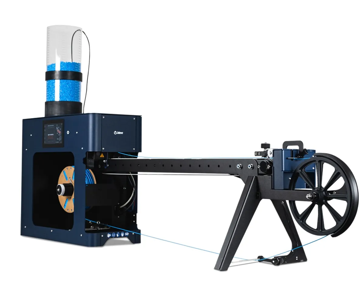 Extrusora de filamento 3devo Filament Maker X10, azul-escura, com funil transparente cheio de grânulos azuis no topo, esteira de resfriamento e bobinadeira com roda grande à direita