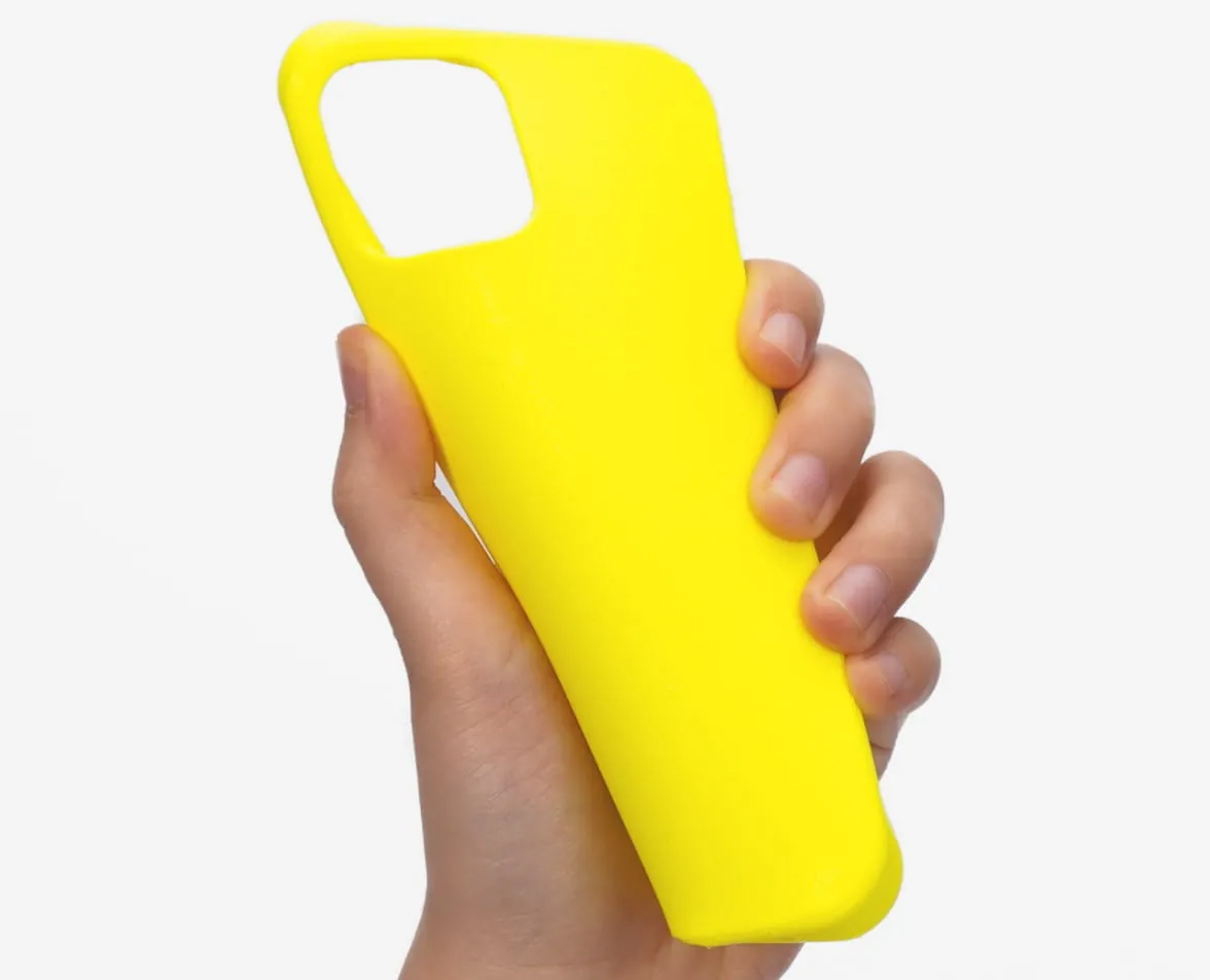 Mão segurando e dobrando uma capa de celular amarela impressa em TPU, sobre fundo branco