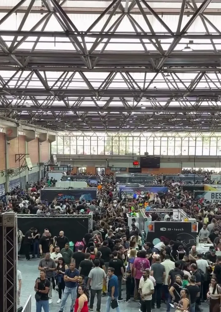 Vista do alto do pavilhão da Expo3DBr 2026 completamente tomado por visitantes, com os corredores entre estandes ocupados por uma multidão