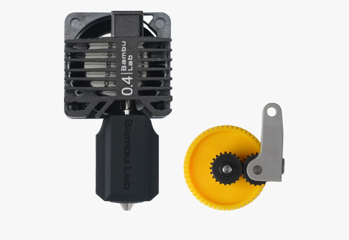 Hotend da Bambu Lab com bico de aço endurecido de 0,4 mm ao lado do par de engrenagens de extrusora, amarela e preta, do kit de atualização para a série P1