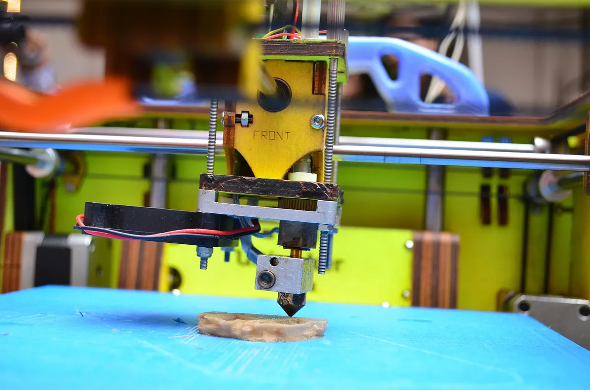 Bico de impressora 3D depositando a primeira camada de uma peça